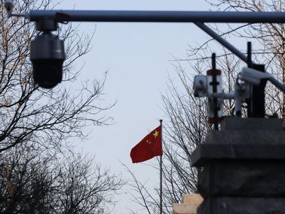 علم الصين بالقرب من كاميرات مراقبة خارج محكمة في العاصمة بكين. 31 مارس 2022 - REUTERS