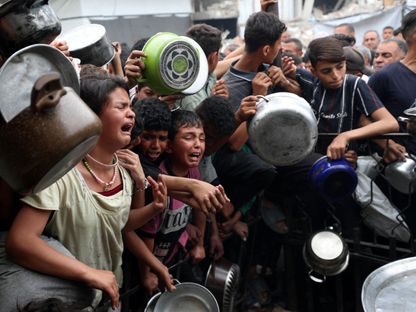 أطفال فلسطينيون ينتظرون الحصول على طعام أعدته جمعية خيرية في بيت لاهيا شمالي قطاع غزة. 24 أبريل 2025 - Reuters
