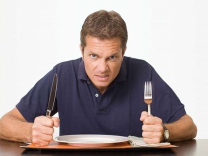 صورة تعبيرة لرجل ينتظر الطعام وتبدو عليه مشاعر الغضب - getty