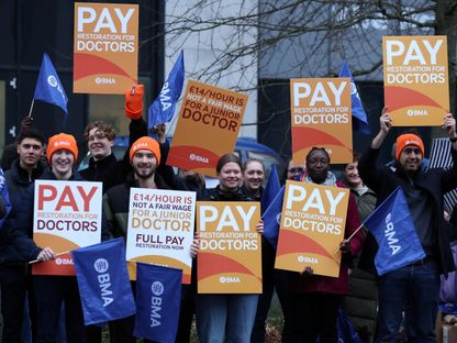 أطباء مبتدئون يحملون لافتات وهم يقفون على خط اعتصام خارج مستشفى الجامعة الملكية خلال إضراب وطني بسبب الأجور وبيئة العمل في ليفربول، بريطانيا. 3 يناير 2024 - REUTERS