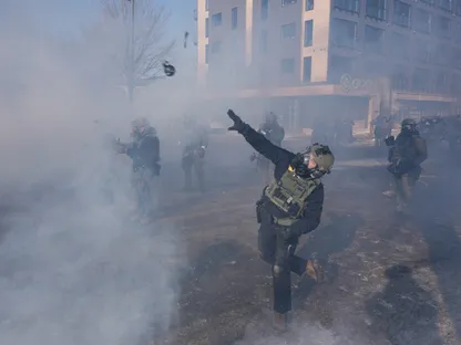 عميل من وكالة إنفاذ القانون الفيدرالية الأميركية يلقي بقنبلة غاز لتفريق الحشود خلال اشتباكات في موقع إطلاق نار تورط فيه عملاء هجرة فيدراليون في مينيابوليس. 24 يناير 2026 - REUTERS