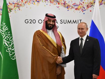 ولي العهد السعودي الأمير محمد بن سلمان يصافح الرئيس الروسي فلاديمير بوتين على هامش قمة العشرين في أوساكا اليابانية. 29 يونيو 2019 - AFP