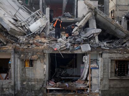 فلسطينيون يتفقدون موقع غارة إسرائيلية على منزل في مدينة رفح جنوبي قطاع غزة. 27 فبراير 2024 - REUTERS