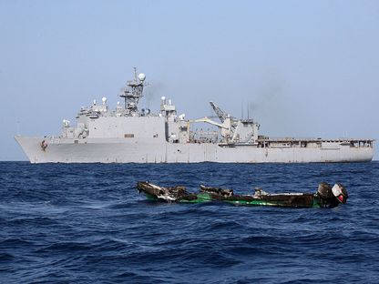 هيكل قارب محترق أمام سفينة الإنزال التابعة للبحرية الأميركية "يو إس إس آشلاند" قبالة سواحل الصومال - Reuters