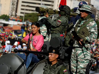 امرأة تحمل سلاحاً إلى جانب جنود في كاراكاس، فنزويلا. 23 سبتمبر 2025 - Reuters
