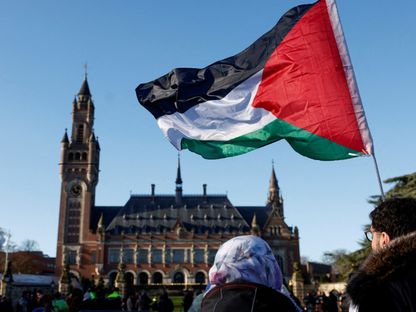 متظاهرون يحملون العلم الفلسطيني خارج محكمة العدل الدولية في لاهاي بهولندا. 26 يناير 2024 - Reuters
