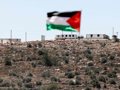 علم فلسطين يرفرف أمام بؤرة استيطانية في قرية بيتا جنوب نابلس بالضفة الغربية- 18 يونيو 2021 - AFP