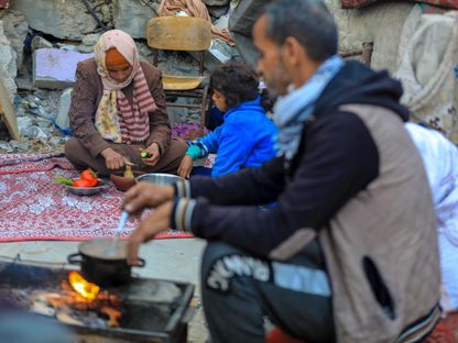 عائلة فلسطينية نازحة في رفح جنوبي قطاع غزة تحاول إعداد بعض الطعام قبل موعد الإطار في رمضان. 18 مارس 2024 - AFP