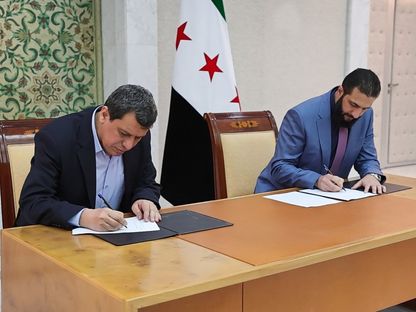 الرئيس السوري أحمد الشرع وقائد قوات سوريا الديمقراطية (قسد) مظلوم عبدي خلال التوقيع على اتفاق يقضي بدمج قوات الأخير في مؤسسات الدولة. 10 مارس 2025 - الرئاسة السورية