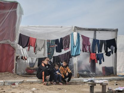 أطفال يجلسون أمام خيمة بالقرب من ساحل غزة، مدينة رفح جنوب غزة. 17 ديسمبر 2023 - AFP