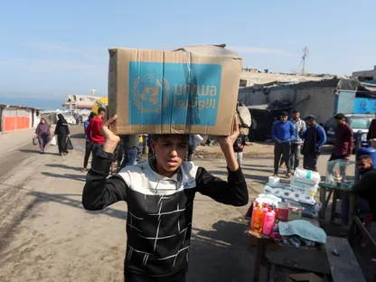 فتى فلسطيني يحمل صندوق مساعدات وزعته وكالة الأمم المتحدة لإغاثة وتشغيل اللاجئين الفلسطينيين (الأونروا)، في دير البلح، وسط قطاع غزة. 4 نوفمبر 2024 - REUTERS