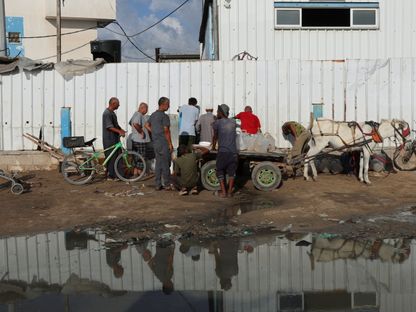 فلسطينيون يتجمعون للحصول على المياه وسط نقص المياه في نقطة توزيع بدير البلح وسط قطاع غزة. 5 أغسطس 2025 - Reuters