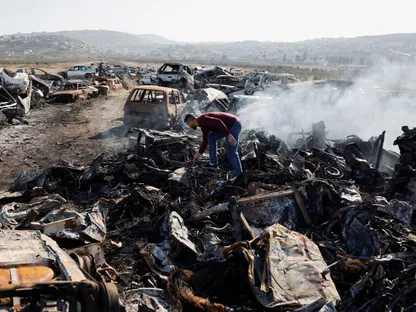 فلسطيني يتفقد سيارات أُحرقت في هجوم نفذه مستوطنون إسرائيليون في حوارة بالضفة. 21 نوفمبر 2025 - REUTERS