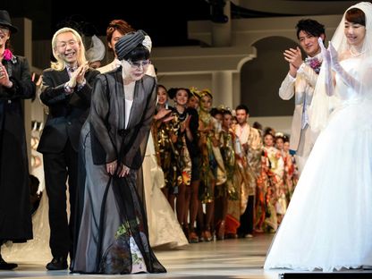 مصممة فساتين الزفاف اليابانية يومي كاتسورا تنحني لتحية حضور أحد عروض دار الأزياء المملوكة لها في طوكيو- 25 فبراير 2015 - AFP