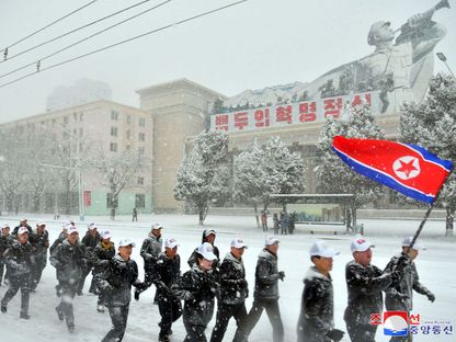 موظفون حكوميون يركضون للاحتفال باليوم الرياضي الأول للعام الجديد في الثلج في بيونج يانج. 14 يناير 2024 - AFP