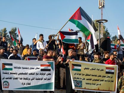 عراقيون يحملون لافتات وأعلام لدعم الفلسطينيين في غزة، في الموصل، العراق. 20 أكتوبر 2023 - REUTERS