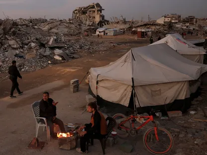 فلسطينيون يحصلون على تدفئة وسط الخيام في مدينة غزة. 17 نوفمبر 2025 - Reuters