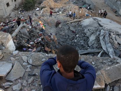 صبي فلسطيني ينظر إلى أنقاض المباني المدمرة في قصف إسرائيلي على رفح جنوب قطاع غزة. 21 أكتوبر 2023 - AFP