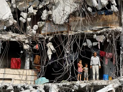 أسرة فلسطينية تقف داخل مبنى مدمر جراء الغارات الإسرائيلية على مدينة غزة. 2 نوفمبر 2025 - REUTERS