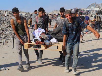 شباب يحملون فلسطينياً مصاباً بنيران إسرائيلية أثناء محاولة الحصول على مساعدات غذائية في بيت لاهيا شمالي قطاع غزة. 3 أغسطس 2025 - REUTERS