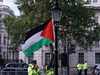 متظاهر يربط علم فلسطين بعمود إنارة مقابل داونينج ستريت، في لندن، بريطانيا، 5 سبتمبر 2019 - Reuters