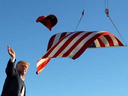الرئيس الأميركي السابق دونالد ترمب يرمي قبعة كتب عليها "أنقذوا أميركا" خلال تجمع انتخابي في ولاية أريزونا. 9 أكتوبر 2022 - REUTERS