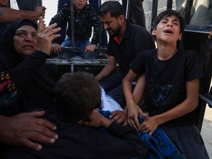 فلسطينيون يبكون أحد أفراد عائلتهم قتلته إسرائيل خلال سعيه للحصول على مساعدات إنسانية في مدينة غزة. 18 يونيو 2025 - REUTERS