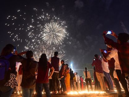 أشخاص يتابعون عرضاً للألعاب النارية احتفالاً بعيد "ديوالي" في الهند، 11 نوفمبر 2023. - AFP