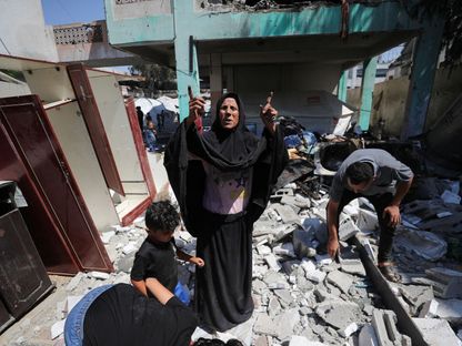 امرأة فلسطينية تقف على أنقاض مدرسة تؤوي النازحين استهدفتها الغارات الإسرائيلية على شمال قطاع غزة. 27 يونيو 2025 - REUTERS
