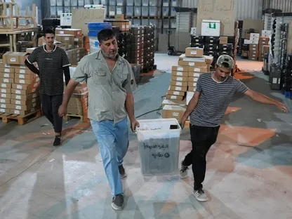 عمال المفوضية العليا للانتخابات في العراق ينقلون صندوق اقتراع في مدينة البصرة جنوب البلاد. 6 نوفمبر 2025 - REUTERS