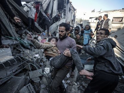 أب فلسطيني يحمل طفلته المصابة جراء غارة إسرائيلية على منزل في مدينة غزة. 30 ديسمبر 2023 - AFP