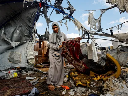 امرأة فلسطينية تحمل سجادة صلاة في موقع غارة إسرائيلية في مدينة غزة. 8 سبتمبر 2025 - Reuters