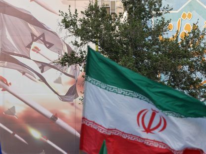 علم إيران بجانب لوحة مناهضة لإسرائيل في العاصمة طهران. 15 أبريل 2024 - REUTERS