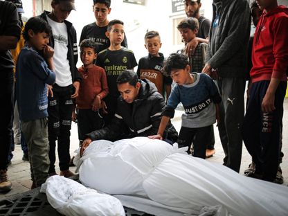 عائلة فلسطينية وأطفال حول جثامين ذويهم ضحايا القصف الإسرائيلي على رفح جنوبي قطاع غزة. 27 أبريل 2024 - AFP