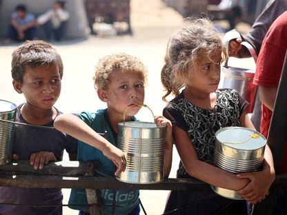 أطفال ينتظرون توزيع الطعام في مخيم للنازحين داخلياً حيث يعيشون في ظل القصف الإسرائيلي على قطاع غزة. خان يونس، فلسطين. 11 يونيو 2024 - AFP