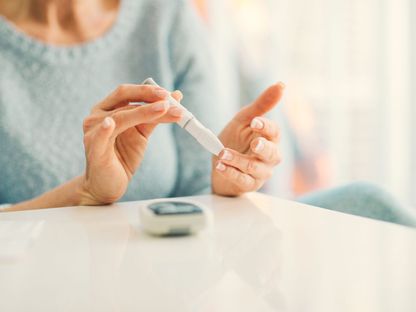 امرأة تستخدم جهاز السكري لقياس نسبة السكر في الدم - Getty Images