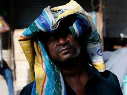 رجل يستخدم منشفة لحماية رأسه من الحرارة خلال يوم صيفي حار في نيودلهي. 28 مايو 2024 - Reuters