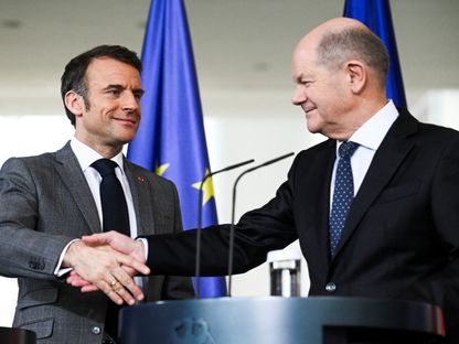 الرئيس الفرنسي إيمانويل ماكرون والمستشار الألماني أولاف شولتز يتصافحان قبل اجتماع في برلين- 15 مارس 2024 - Reuters