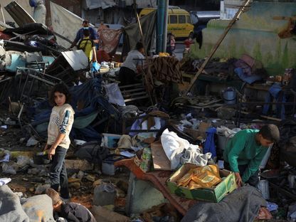 فلسطينيون يتفقدون أنقاض مدرسة كانت تؤوي نازحين في أعقاب غارة إسرائيلية دمرتها في مدينة غزة. 26 مايو 2025 - REUTERS