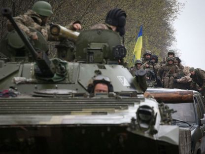 جنود أوكرانيون يقفون على ناقلة جنود بالقرب من خط المواجهة مع القوات الروسية في مقاطعة إيزيوم بإقليم خاركوف. 18 إبريل 2022 - AFP