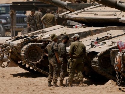 جنود إسرائيليون أمام الدبابات على الحدود مع قطاع غزة بينما يتواصل القصف الجوي والغارات. 29 يوليو 2025 - REUTERS