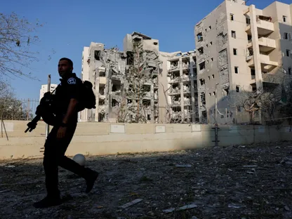 أحد أفراد قوات الأمن الإسرائيلي يسير بجوار موقع سكني متضرر في أعقاب هجوم صاروخي من إيران على إسرائيل في بئر السبع. 24 يونيو 2025 - reuters