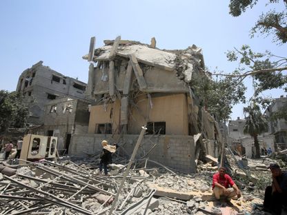 فلسطينيون وسط أنقاض منازل متضررة جراء غارة إسرائيلية على مناطق متفرقة في مدينة غزة. 1 يونيو 2025 - REUTERS