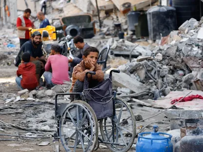 فلسطينيون بجوار أنقاض مبان مدمرة في مدينة غزة. 2 نوفمبر 2025 - Reuters