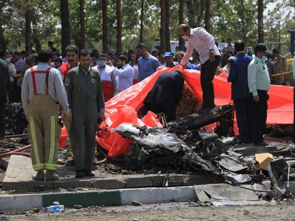 مسؤولون إيرانيون يتفقدون حطام طائرة ركاب في مطار مهر أباد بالعاصمة طهران. 10 أغسطس 2014 - AFP