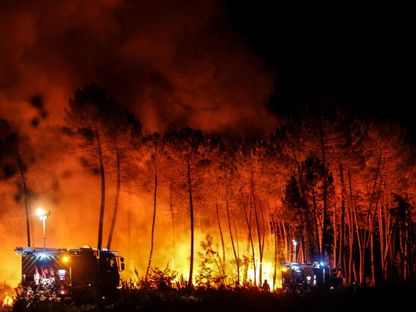 رجال الإطفاء  أثناء محاولتهم منع انتشار حريق بسبب تغير الرياح  بالقرب من Loachats في جيروند ، جنوب غرب فرنسا - AFP