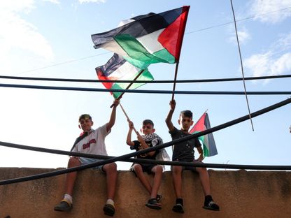 أطفال يحملون أعلاماً فلسطينية في مخيم برج البراجنة للاجئين في بيروت. لبنان في 11 أكتوبر 2023. - Reuters