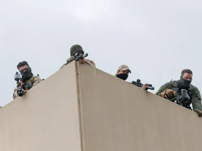عناصر من قوات الأمن يحملون أسلحة يقفون على سطح مبنى هيئة إنفاذ قوانين الهجرة والجمارك خلال احتجاج في بورتلاند، ولاية أوريجون، الولايات المتحدة. 4 أكتوبر 2025 - REUTERS