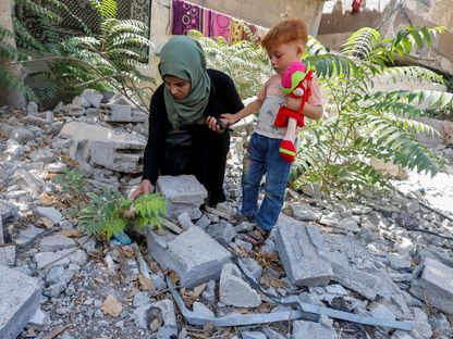 الفلسطينية إيناس أبو معمر تزور مع ابن أخيها (أحمد) مقبرة مدمرة دفنت فيها شقيقته (سالي) في خان يونس جنوب قطاع غزة. 11 سبتمبر 2024 - REUTERS