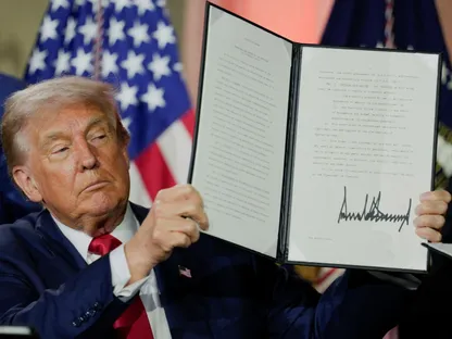 الرئيس الأميركي دونالد ترمب يحمل أمراً تنفيذياً يتعلق بالذكاء الاصطناعي بعد توقيعه خلال قمة "الفوز في سباق الذكاء الاصطناعي" في واشنطن. 23 يوليو 2025 - Reuters